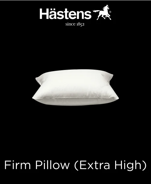 Thick, white Hastens Firm Extra High Pillow resting on a simple bed frame